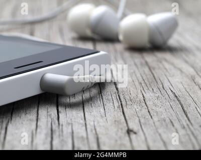 closeup of earphones mini-jack connector on smartphone, macro, shallow depth of field Stock Photo