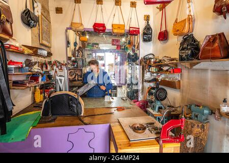 Leather craftsman builds a handmade bag in his workshop. Isernia, Molise, Italy, Europe Stock Photo