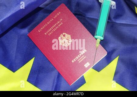 Symbolbild Reisefreiheit: Deutscher Reisepass und Injektionsnadel auf einer europäischen Flagge Stock Photo