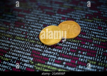 Two gold bitcoin coins on the background of lines of program code Stock Photo