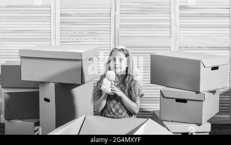 Packaging things. Only true friend. Girl child play with toy near boxes. Move out concept. Stressful situation. Divorce and separation. Family problem Stock Photo