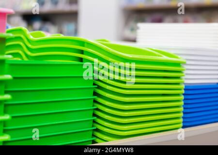 Photo of new packed multi colored plastic containers stacked on store shelf. Stock Photo