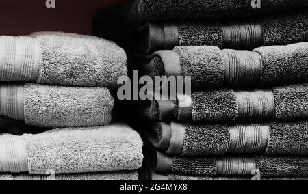 Photo of new grey colored towels stacked on store shelf. Stock Photo