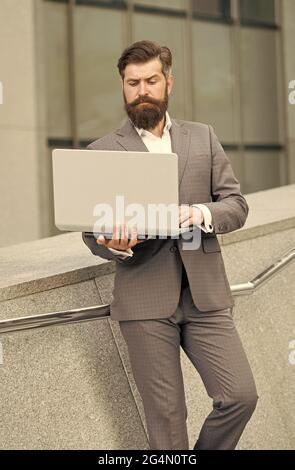 Computer communication network. Bearded man use computer outdoors. Business communication. Making video call. E-mail mail and messaging. Internet Stock Photo