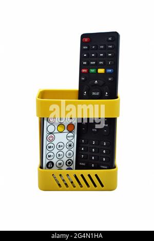 Wall mounted plastic organizer rack with different remote controls in it Stock Photo