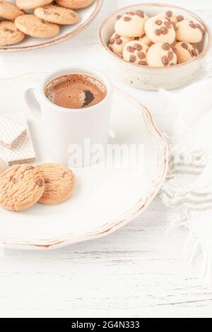 cup of coffee served with variety of cookie and biscuits on table Stock Photo