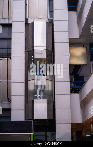 Handsome businessman is going up with the elevator while comunicating on his phone Stock Photo