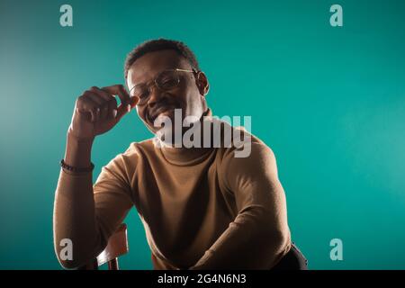 Handsome black male is smiling while posing on the chair Stock Photo