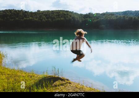 Unrecognizable man falling in lake on sunny day in dolomites in Italy Stock Photo