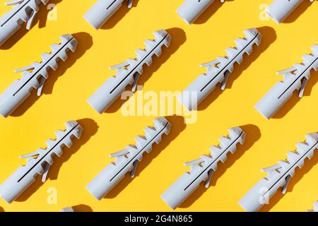 Top view of plastic dowels with holes on ribbed surface in row Stock Photo