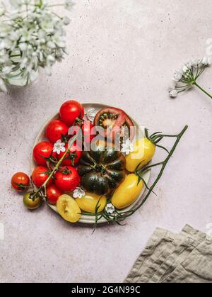 Top view of vegetarian tomato salad on plate on gray concrete table Stock Photo