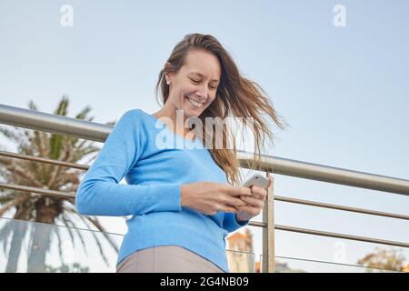 Side view of middle aged female with closed eyes leaning on hand while sitting on passenger seat during ride in wagon looking outside through the wind Stock Photo