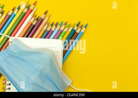 Back to school, pandemic coronavirus concept, flat lay composition, school supplies and stationery on the yellow desktop, copy space and top view Stock Photo