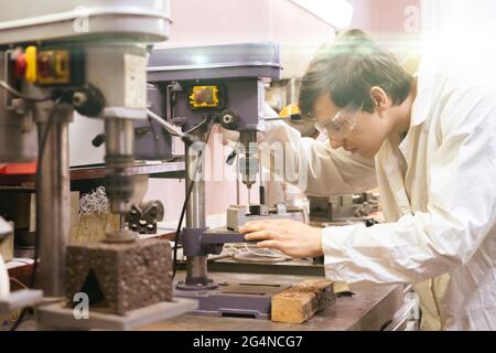 young male industrial worker doing job on the factory manufacture, industrial profession Stock Photo