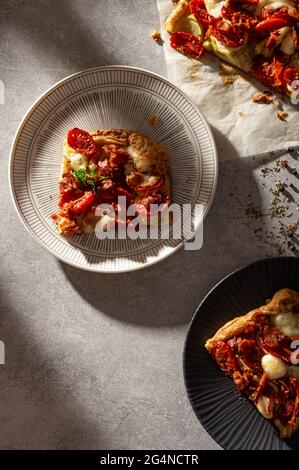 Homemade French open pie quiche with zucchini, tomatoes, mozzarella and bacon. Stock Photo