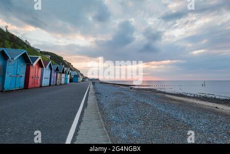 Beach huts along the Cromer seafront seen on the West beach before sunset in June 2021. Stock Photo