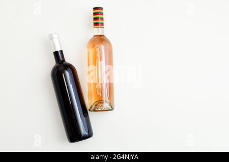 Rose wine bottle and red wine bottle . Minimalistic wine composition top view on white background. Two bottles of Wine brand mockup. Flat lay with Stock Photo