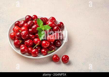 Vichy and mint in a white plate on a pink background. Side view, space for copying. Stock Photo