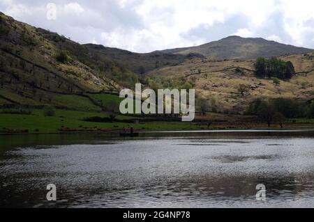 Watendlath Tarn, near the hamlet of Watendlath in the English Lake District. Anglers can often be seen fly fishing for trout from boats on the tarn. Stock Photo