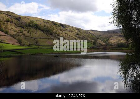 Watendlath Tarn, near the hamlet of Watendlath in the English Lake District. Anglers can often be seen fly fishing for trout from boats on the tarn. Stock Photo
