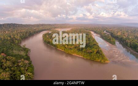 Aerial view of a heart shaped island in Rio Napo, the Ecuadorian Amazon at dawn. The early morning sunlight is illuminating the treetops. Stock Photo
