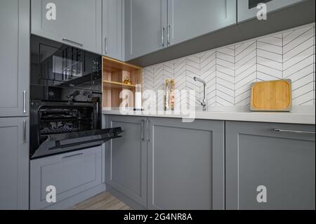 Closeup to corner of grey and white modern kitchen furniture Stock Photo