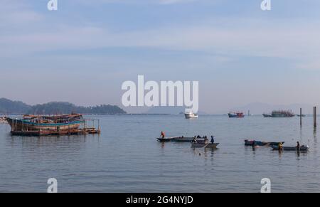 Kota Kinabalu, Malaysia - March 17, 2019: Fishermen wash fishing nets in sea Stock Photo