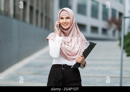 Muslim business woman in formal clothes and hijab standing on