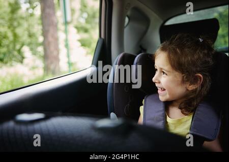 Girl sitting in car booster seat Stock Photo - Alamy