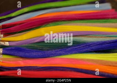 strands of natural dyed hair of bright colors in the palette on the table Stock Photo