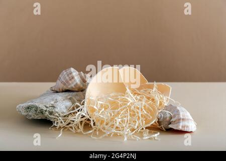 Empty pedestal Mockup on beige background made from seashell stones and eggshell for cosmetic products presentation. Podium on kraft brown paper Stock Photo