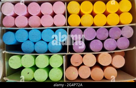 Different colored chalks are neatly arranged in a box. Stock Photo