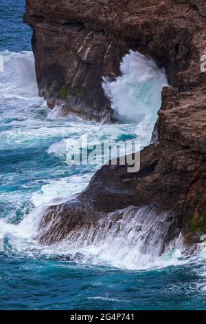 Waves crash against the cliffs at the KILAUEA WILDLIFE REFUGE - KAUI, HAWAII Stock Photo