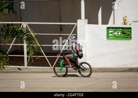 Minca, Magdalena, Colombia - May 20 2021: Little Kid Riding his Bike on the Street in a Sunny Day Stock Photo