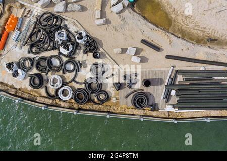 Reconstruction maintenance a stack black PVC sewer pipes for drainage the ground of pier boardwalk on replacement Stock Photo