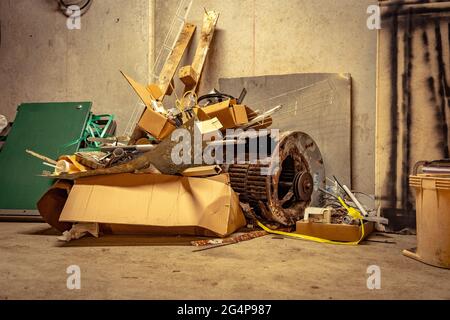 A pile of scrap metal rubbish dumped on the concrete floor Stock Photo