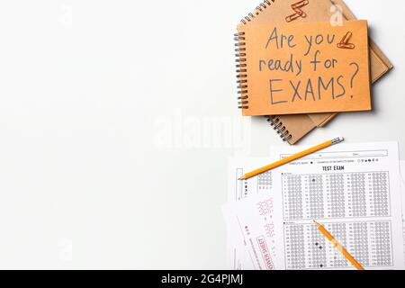Stationery, answer sheets and notebook with text ARE YOU READY FOR EXAMS? on white background Stock Photo