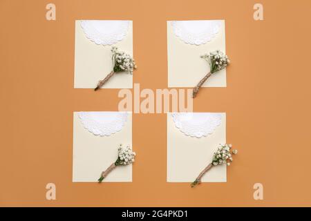 Beautiful gypsophila boutonnieres and wedding invitations on color background Stock Photo