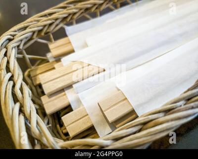 Closeup of disposable chopsticks made from balsa wood in a cane basket in a Japanese restaurant Stock Photo