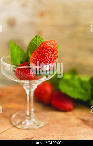 Green apples, Mint and Strawberries on a chopping board in cooking preparation. Stock Photo