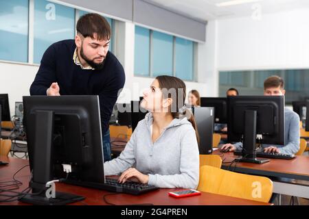Teacher helping student in computer class Stock Photo