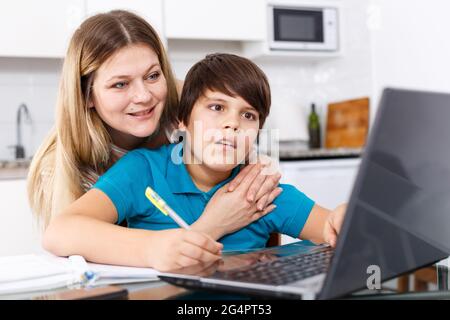 Family doing homework at kitchen Stock Photo