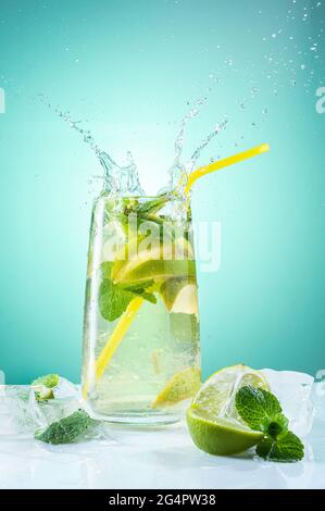 Refreshing mojito with ice. Bright mojito with mint. Refreshing cool drink. Beautiful splash over the glass. Vertical frame. Stock Photo
