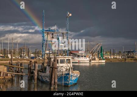 Rainbow over shrimp boats at port basin in Port Lavaca, Texas, USA Stock Photo