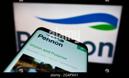 Cellphone with website of British water utility company Pennon Group plc on screen in front of business logo. Focus on top-left of phone display. Stock Photo