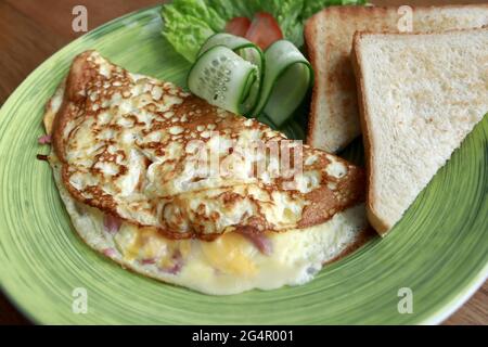 Omelet with vegetables and toast bread on plate Stock Photo