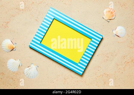Picture frame with copy space and sea shells on sand as a summer background Stock Photo
