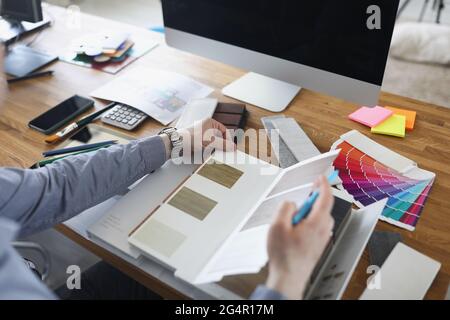 Male designer chooses flooring pattern for home closeup Stock Photo