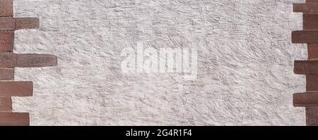 Plastered old panoramic wall framed by red sandstones Stock Photo