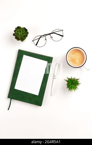 Light vertical postcard mockup for design presentation on a white workplace with coffee, notebook, pen, glasses and potted flowers. Stock Photo